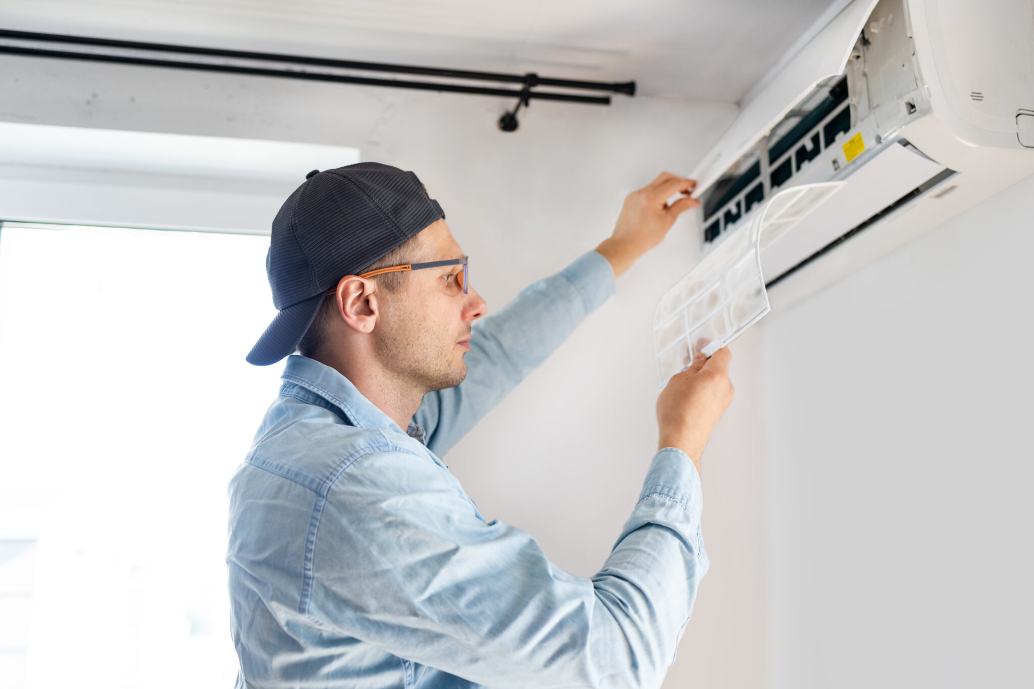 jeune technicien homme réparant un climatiseur à